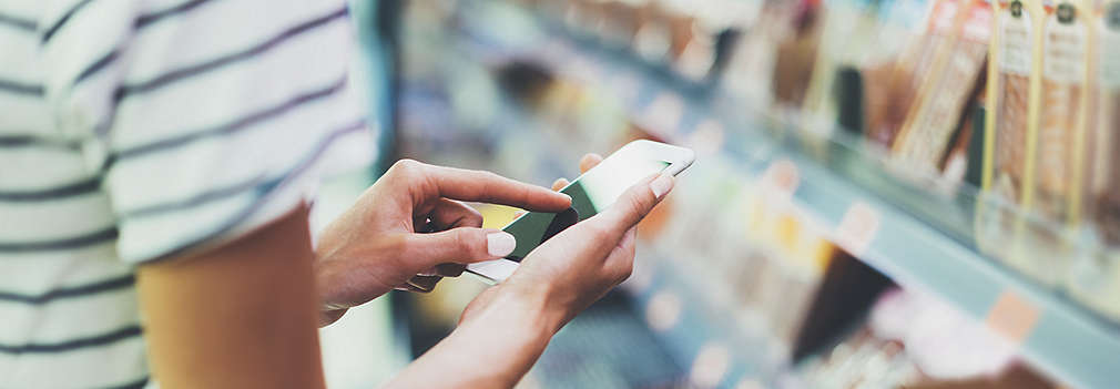 Person sucht auf einem Smartphone nach Informationen