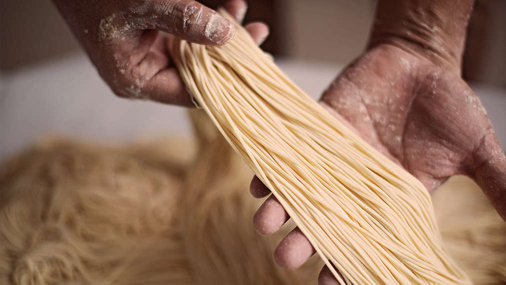 Někdo drží čerstvě vyrobené těstoviny
