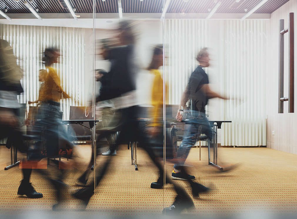 People walk quickly through an office