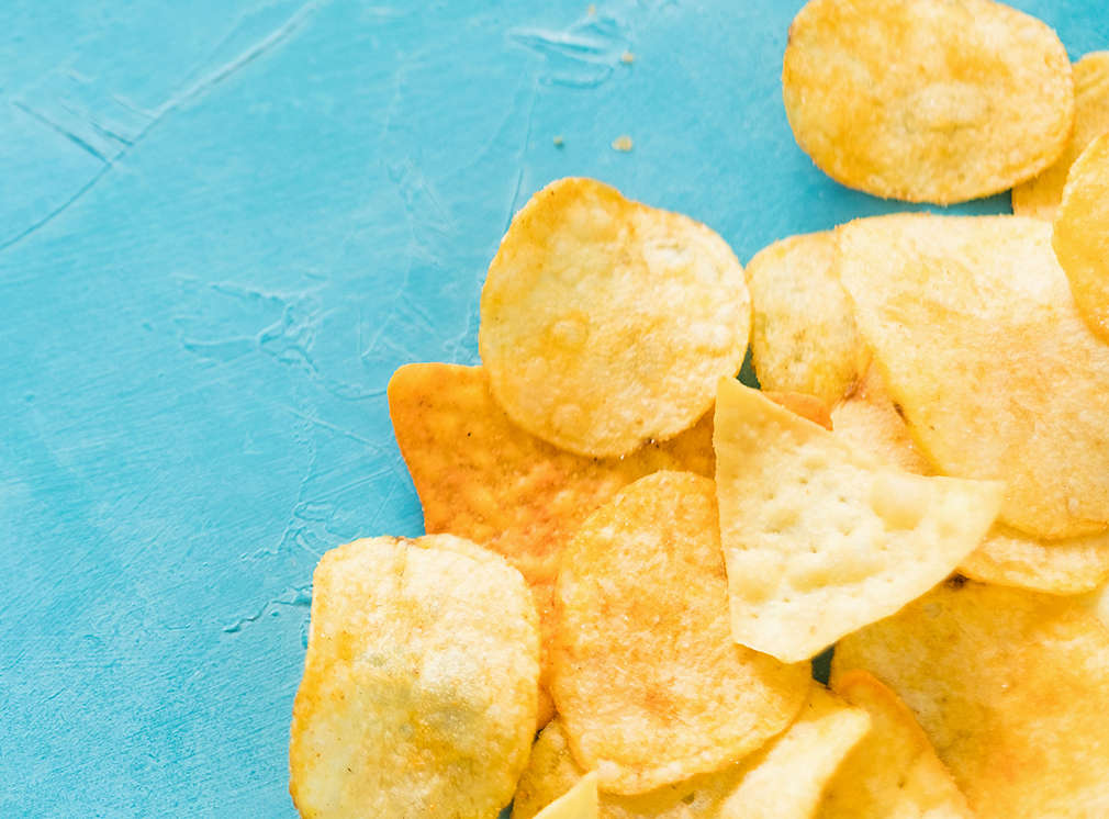 unhealthy fast food snacks. bad nutrition habits. crispy delicious nacho chips on blue background