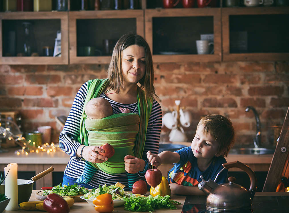 Mutter kocht mit Baby und Kind