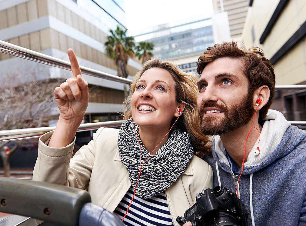 Zwei Personen in einem Sightseeing-Bus schauen sich die Stadt an.