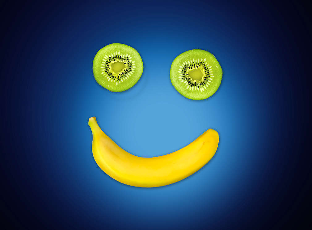 Dva kolieska kivi a banán zobrazujú usmievajúcu sa tvár