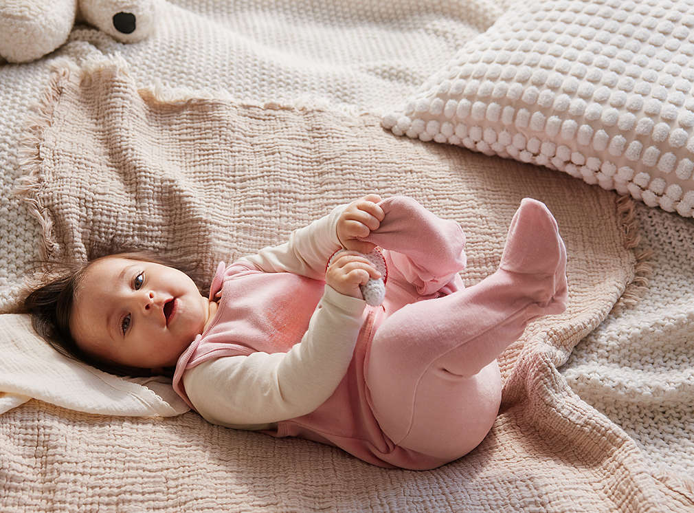 Abbildung: Baby liegt auf einer Decke