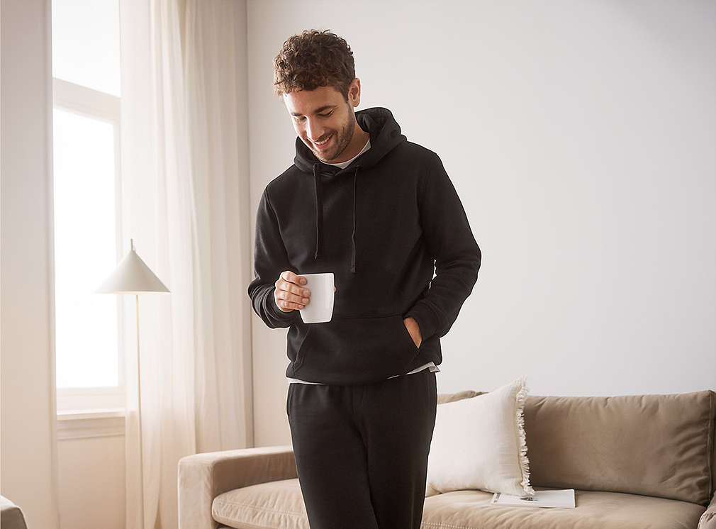 Mann mit Kaffeetasse in der Hand in einem Wohnzimmer