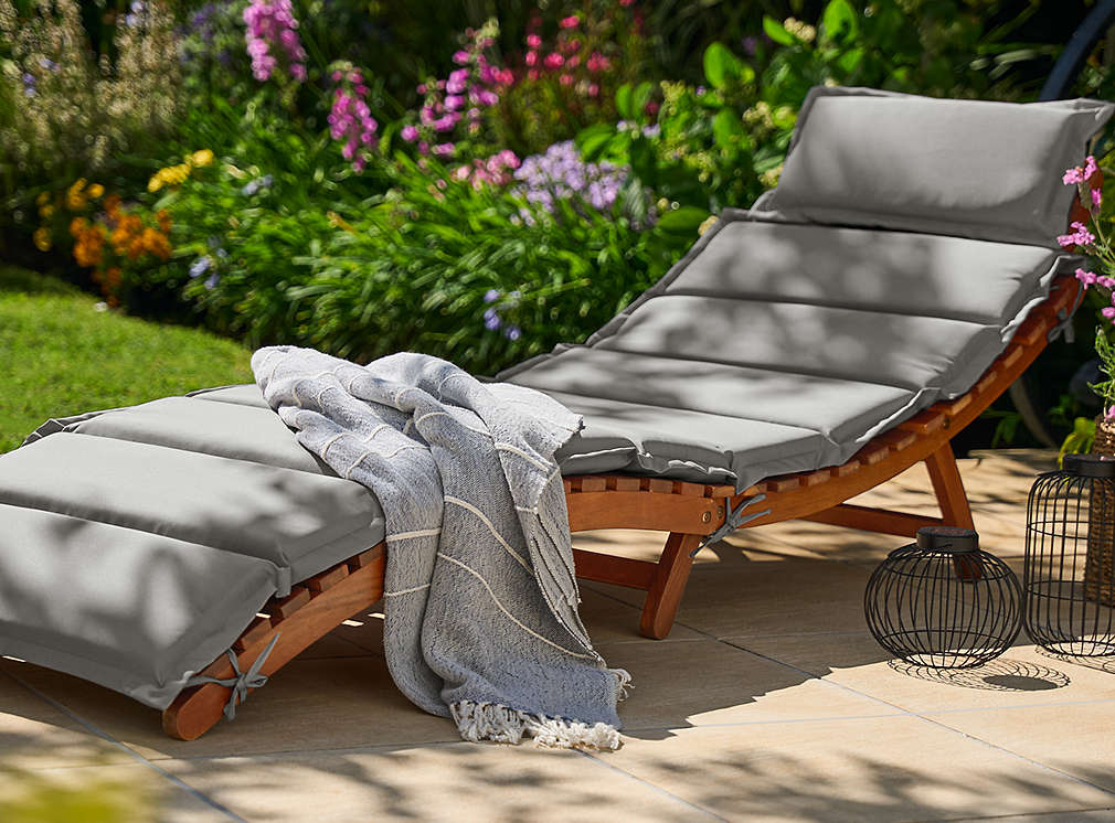 Sonnenliege mit Auflage in einem Garten 