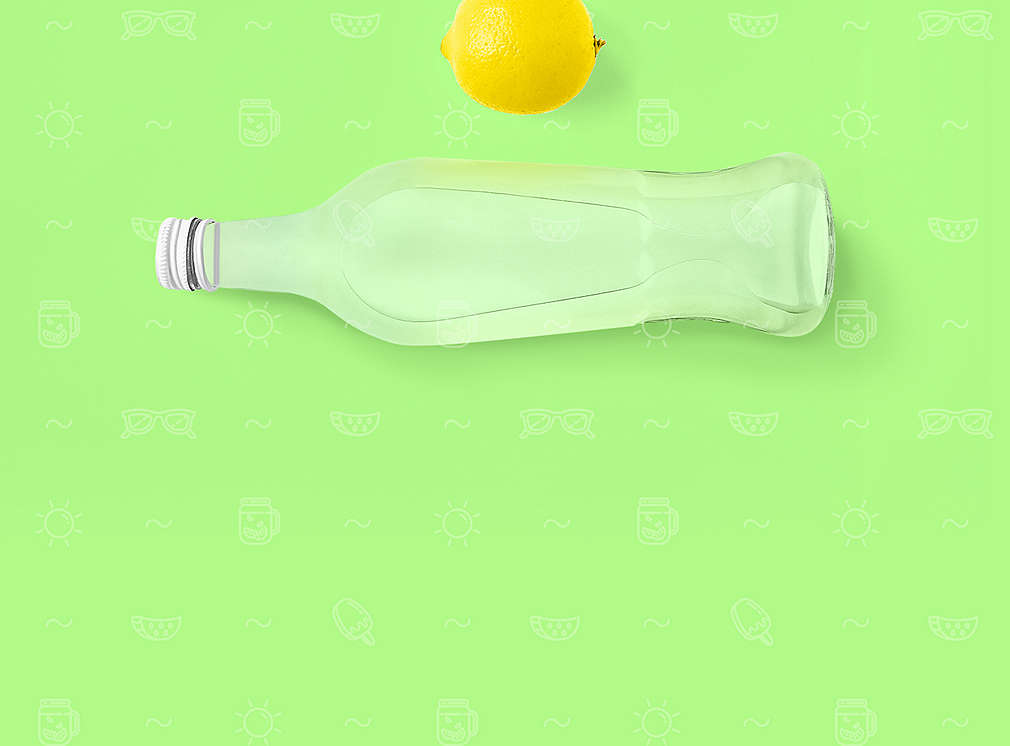Limonade und eine Zitrone auf grünem Hintergrund 