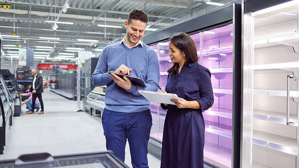 Ein Mann und eine Frau prüfen an einem Tablet etwas.