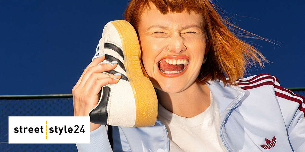 Radosna kobieta trzymajca buta sportowego jak słuchawkę telefonu