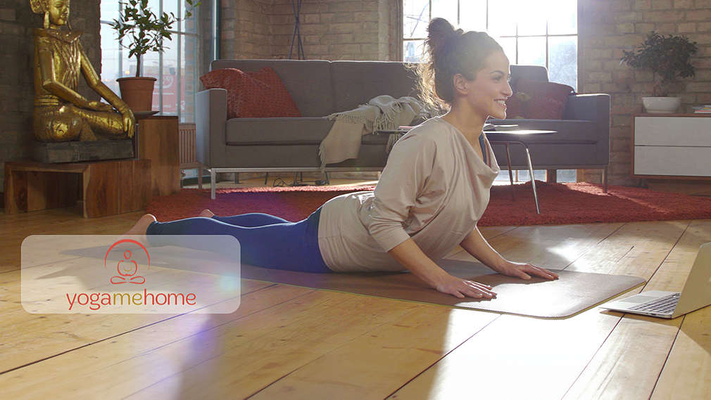 Abbildung: Eine Frau macht Yoga; Logo: YogaMeHome