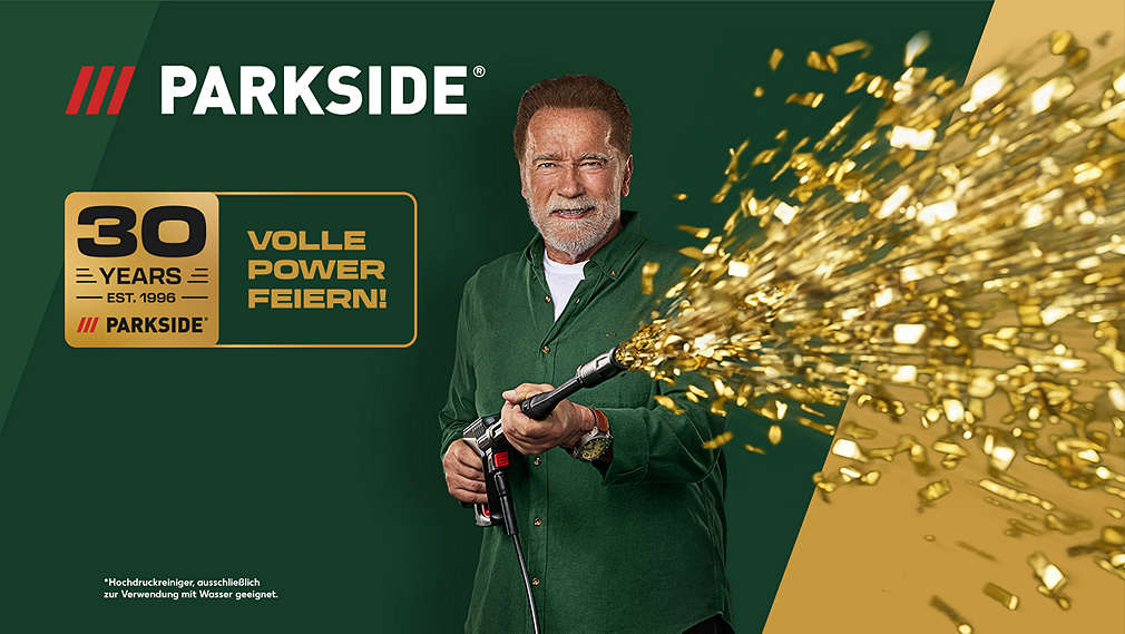 PARKSIDE Logo; Arnold Schwarzenegger mit Hochdruckreiniger von PARKSIDE, aus dem goldenes Konfetti schießt (Hochdruckreiniger ausschließlich zur Verwendung mit Wasser geeignet.); Logo: 30 years - est. 1996 - PARKSIDE