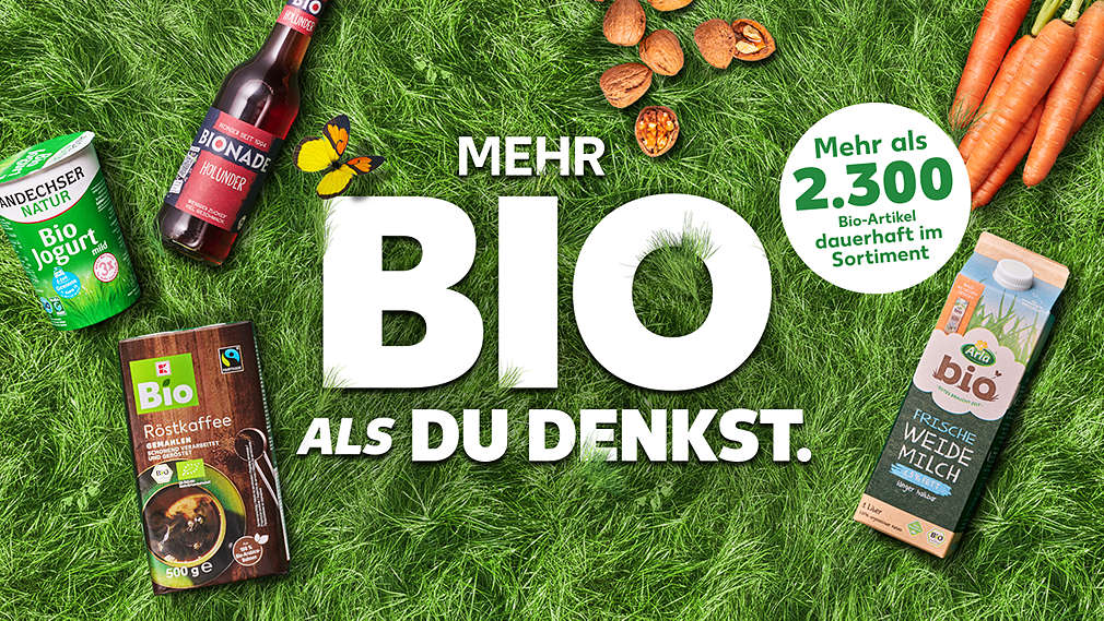 Verschiedene Bio-Lebensmittel auf einer Wiese, Schriftzug: Mehr bio als du denkst. Störer: Mehr als 2.000 Bio-Artikel dauerhaft im Sortiment