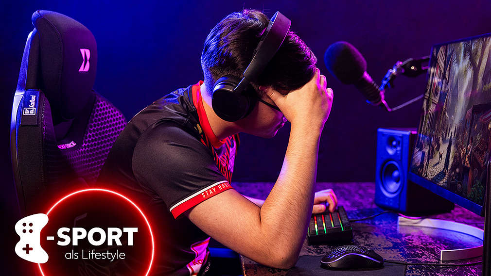 E-Sportler während des Spiels, der seinen Kopf mit der Hand stützt.