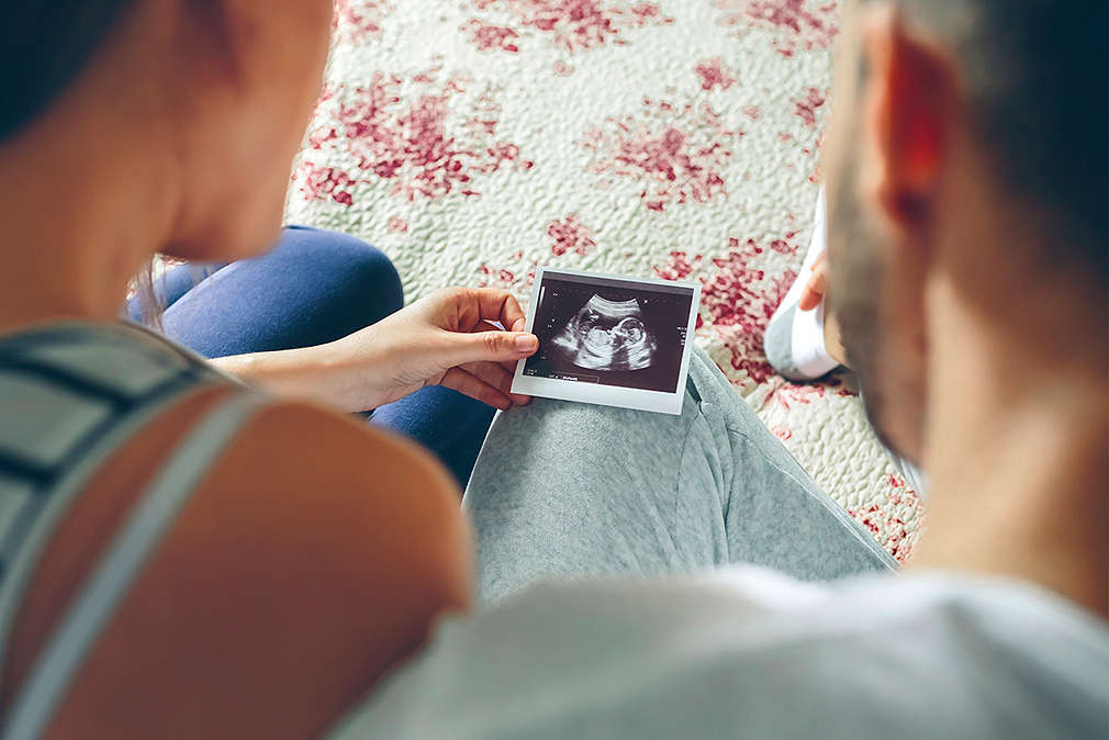 Изображение на млади мъж и жена, които гледат снимка от видеозонн.