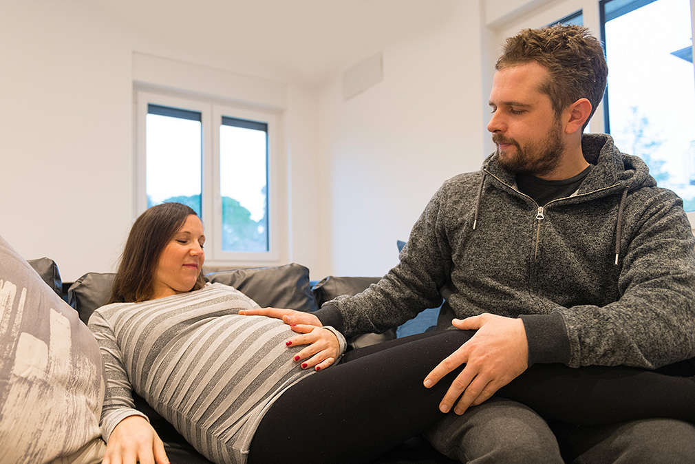 Изображение на бременна жена и партньора й, който й прави масаж.