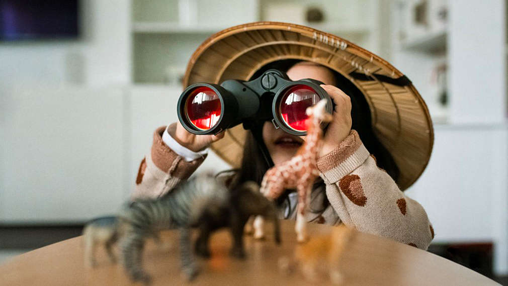 Kind mit Safarihut und Fernglas