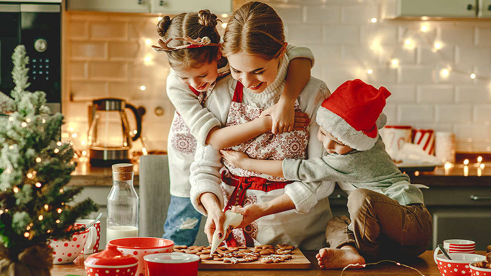 Mutter backt mit ihren beiden Kindern Plätzchen