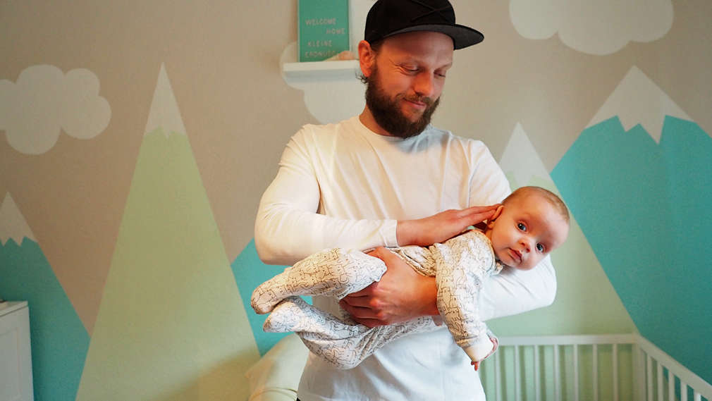 Vater nimmt Baby in den Fliegergriff