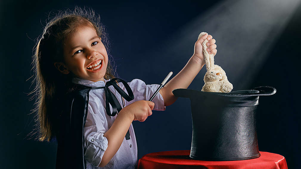 Mädchen zaubert Kanninchen aus dem Hut