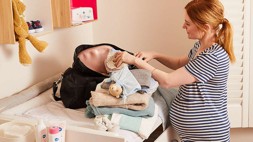 Schwangere Frau packt Tasche