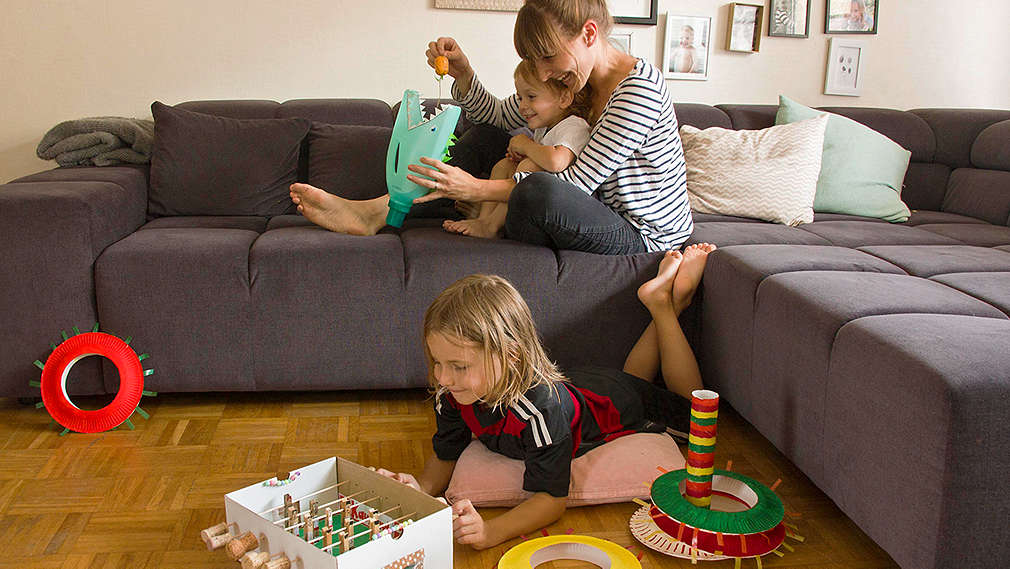 Mutter und Kinder spielen im Wohnzimmer