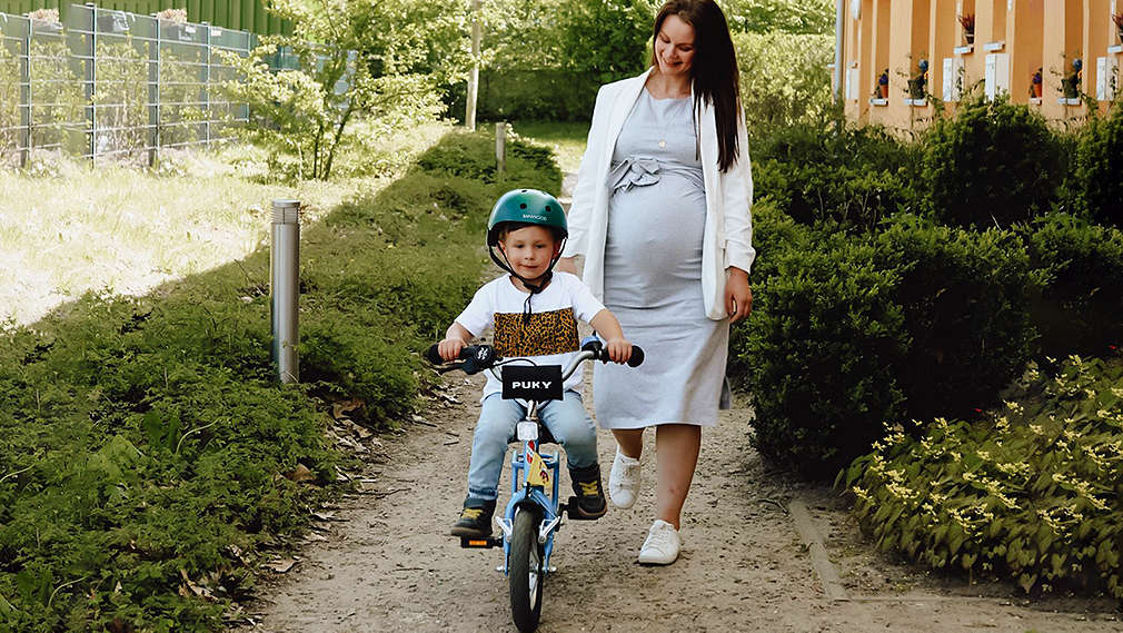 Mutter begleitet ihr Kind beim Fahrradfahren