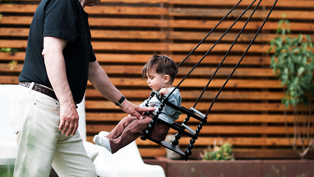 Kind in Holzschaukel