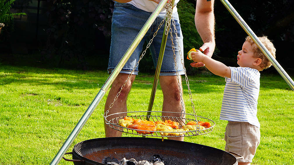 Vater mit Kleinkind am Grill