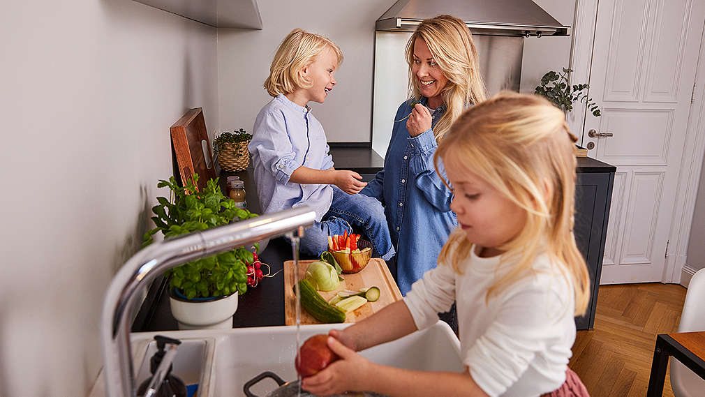 Familie in der Küche beim Gemüse schneiden
