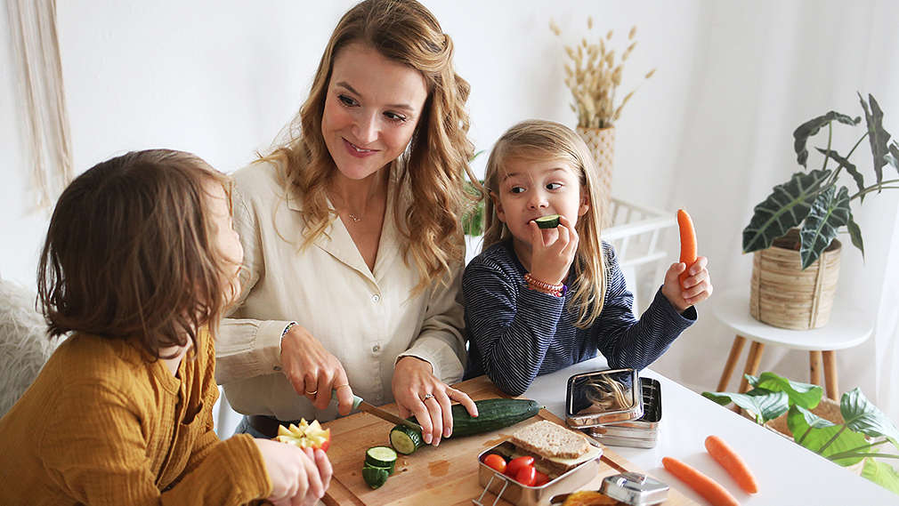 Mutter mit zwei Kindern am Frühstückstisch