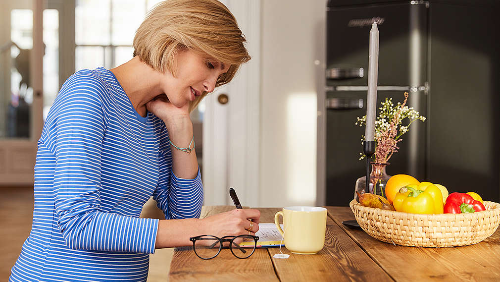 Schwangere Frau am Küchentisch