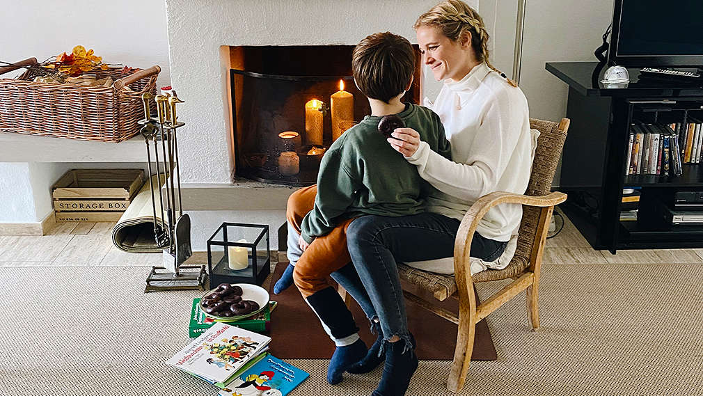 Mutter und Kind sitzen vor einem Kamin