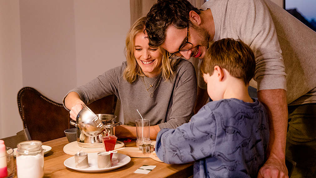 Mutter, Vater und Kind gießen Kerzen