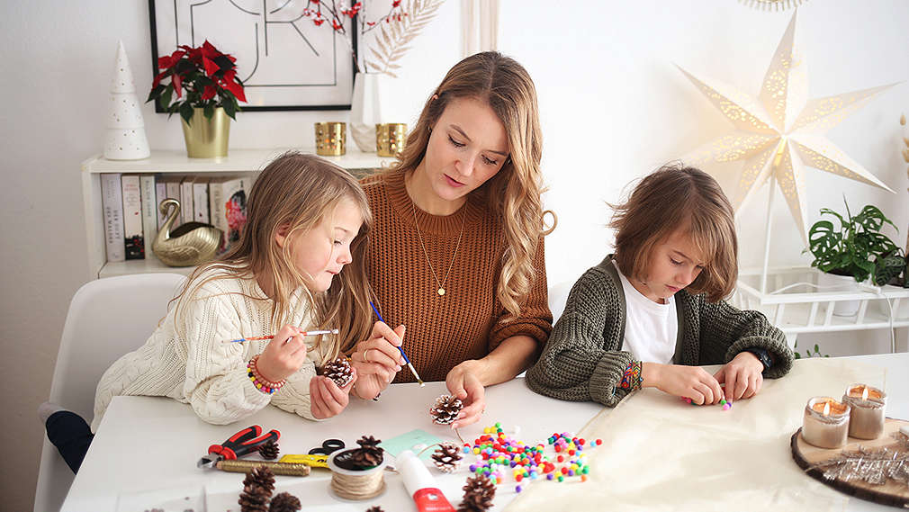 Mutter bastelt mit ihren Kindern Weihnachtsdekoration