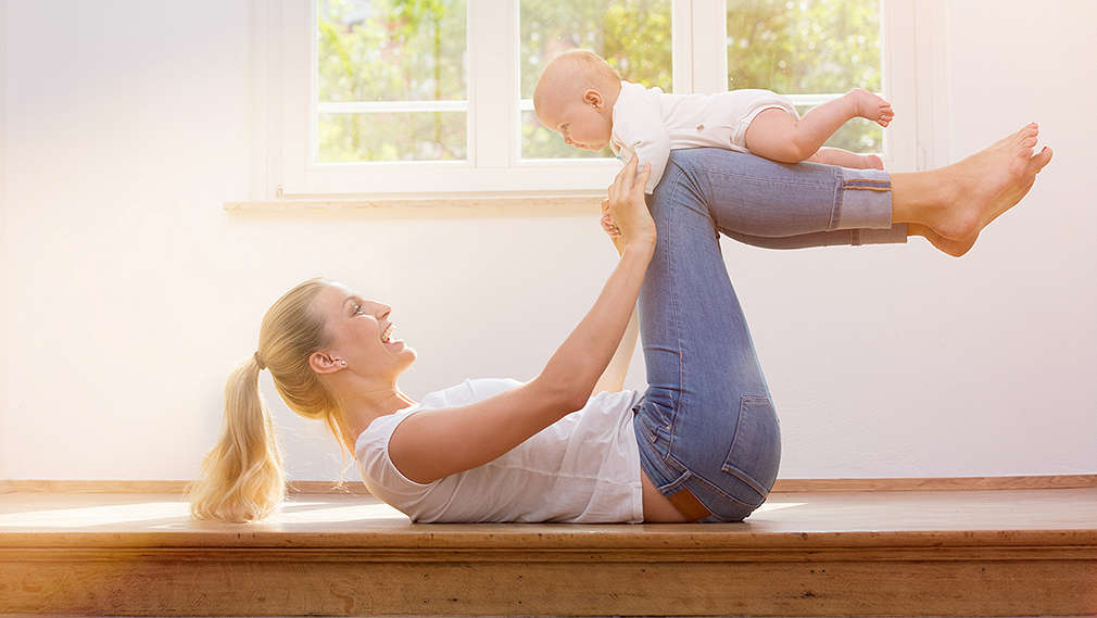 Junge Mutter mit Baby bei der Rückbildungsgymnastik
