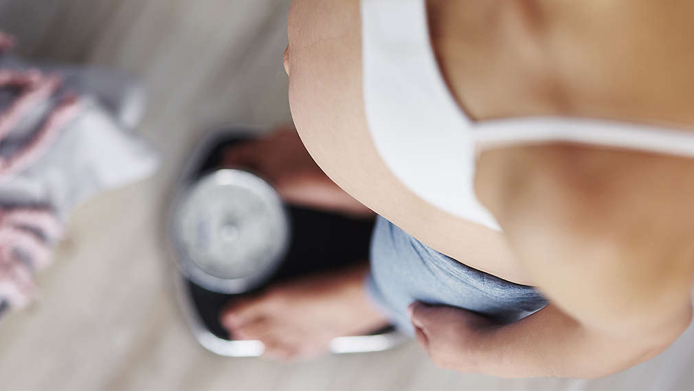 Schwangere Frau auf der Waage