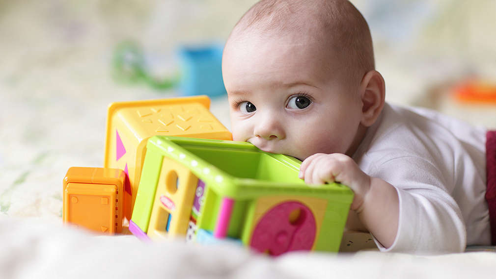 Baby nuckelt an Spielzeug