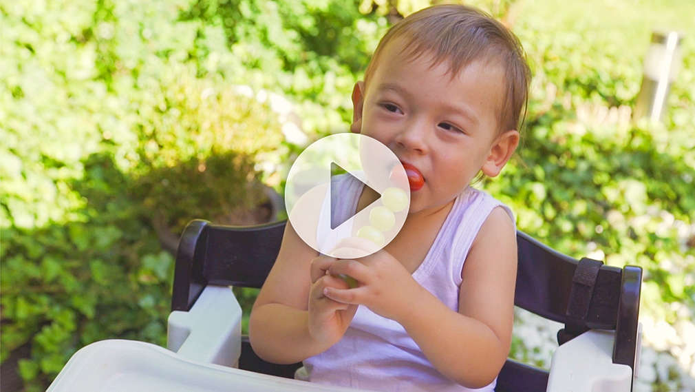 Junge beißt in Früchtespieß