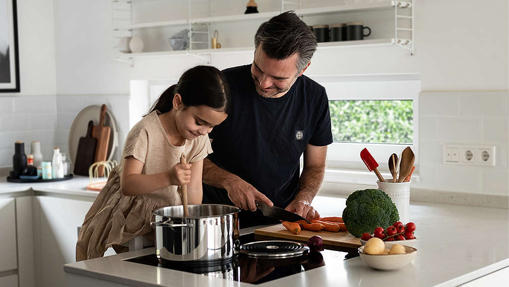 Vater und Tochter kochen gemeinsam am Herd