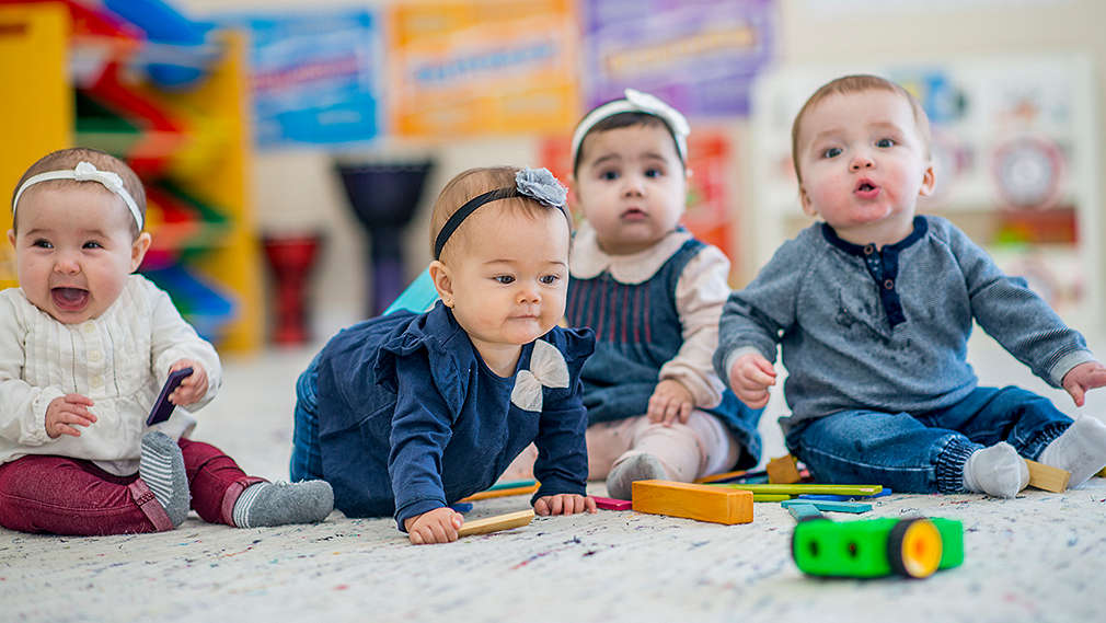 Babys sitzen auf dem Boden