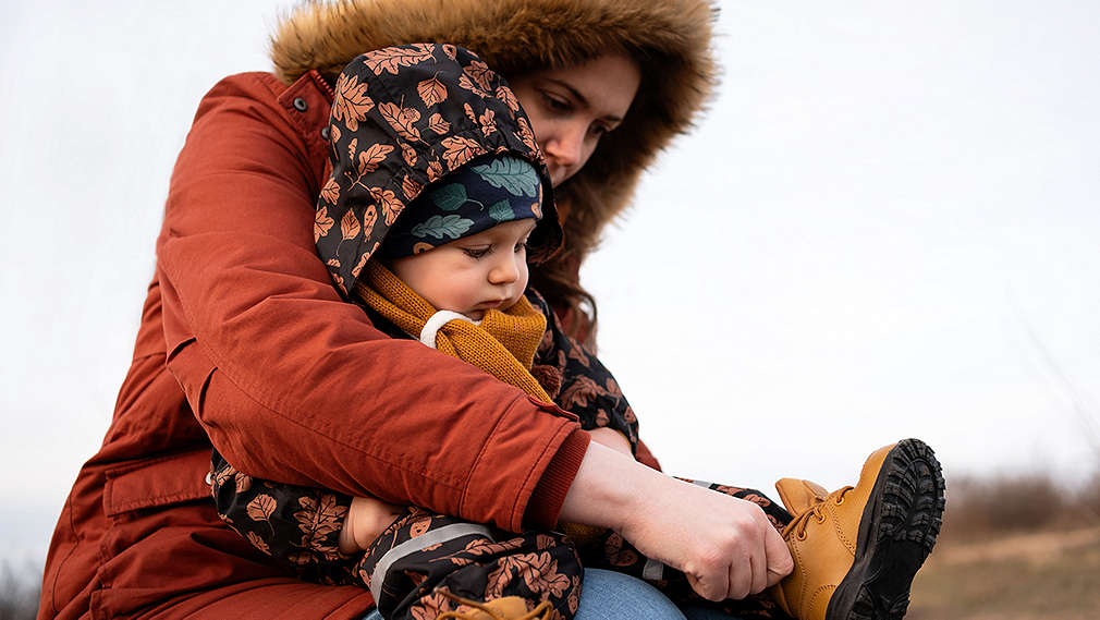 Frau zieht Baby Schuhe an