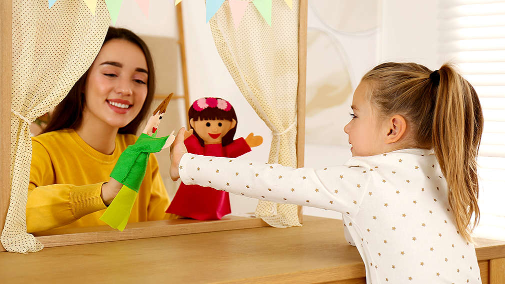 Zwei Mädchen spielen Puppentheater 