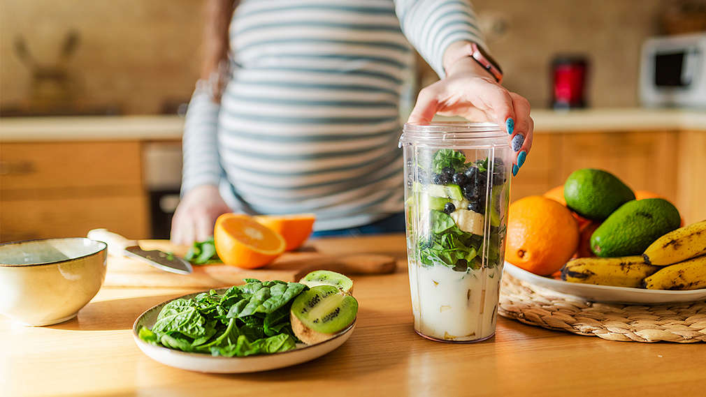 Schwangere bereitet Mahlzeit zu