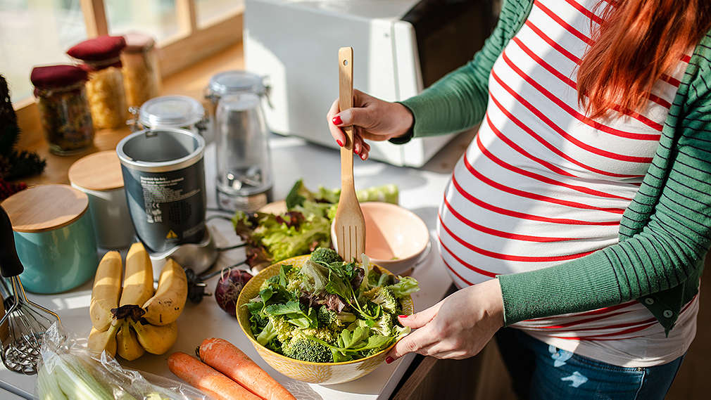 Schwangere bereitet Mahlzeit zu