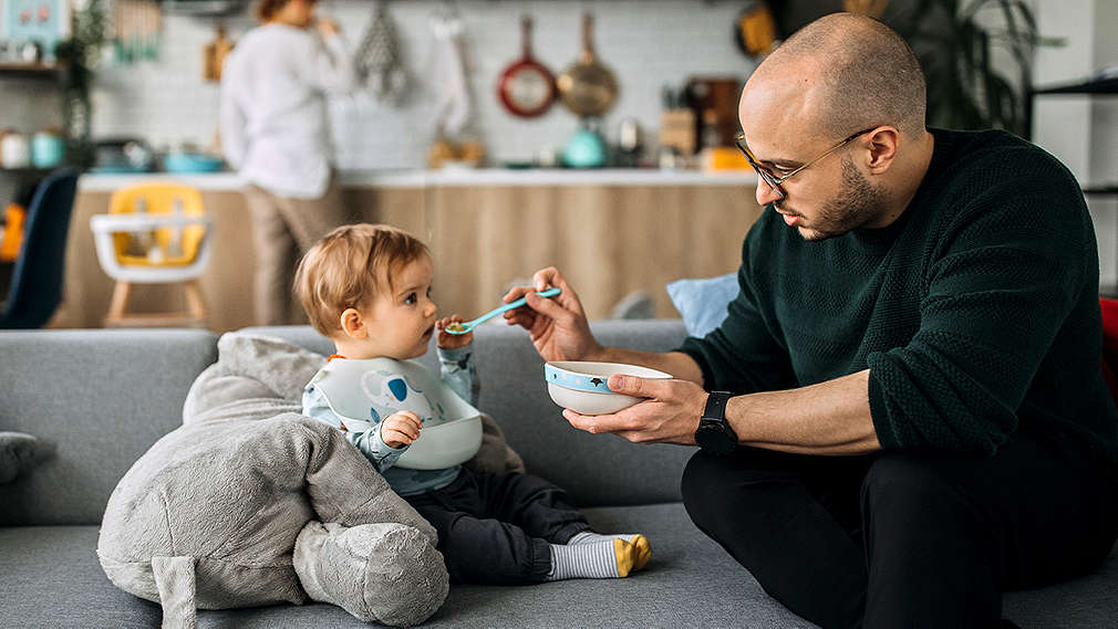 Vater füttert sein Kind