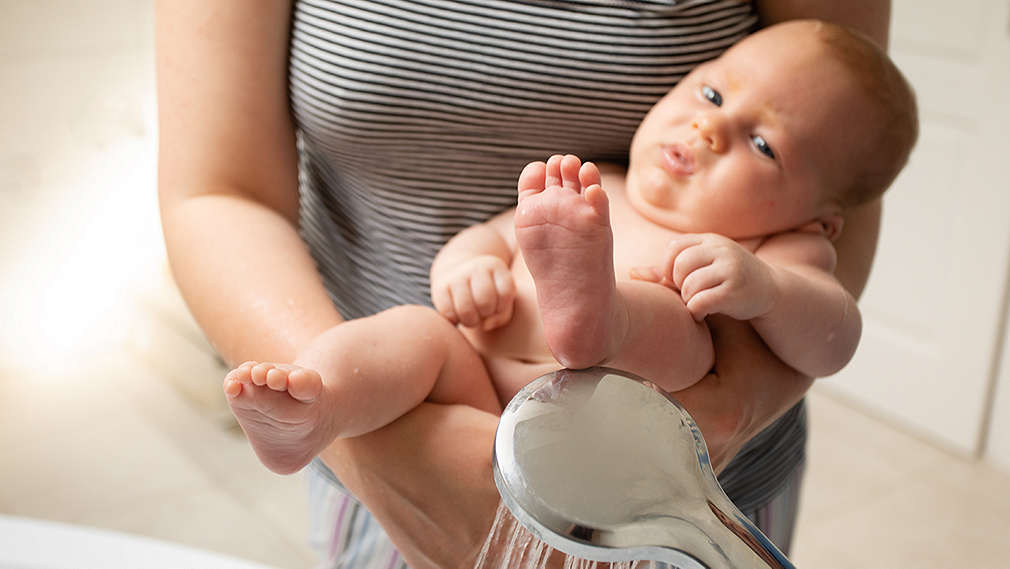 Baby beim Abhalten im Arm seiner Mutter