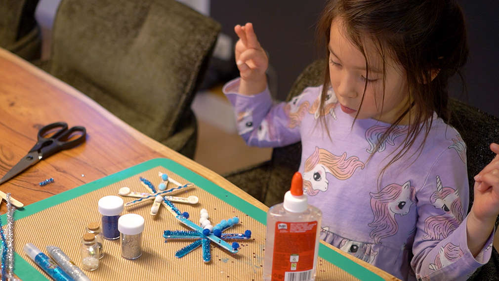 Mädchen bastelt am Tisch