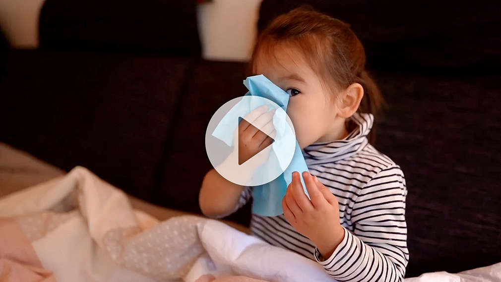 Krankes Kind putzt sich die Nase