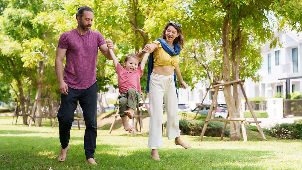 Mutter und Vater machen Bewegungsspiel mit Kind