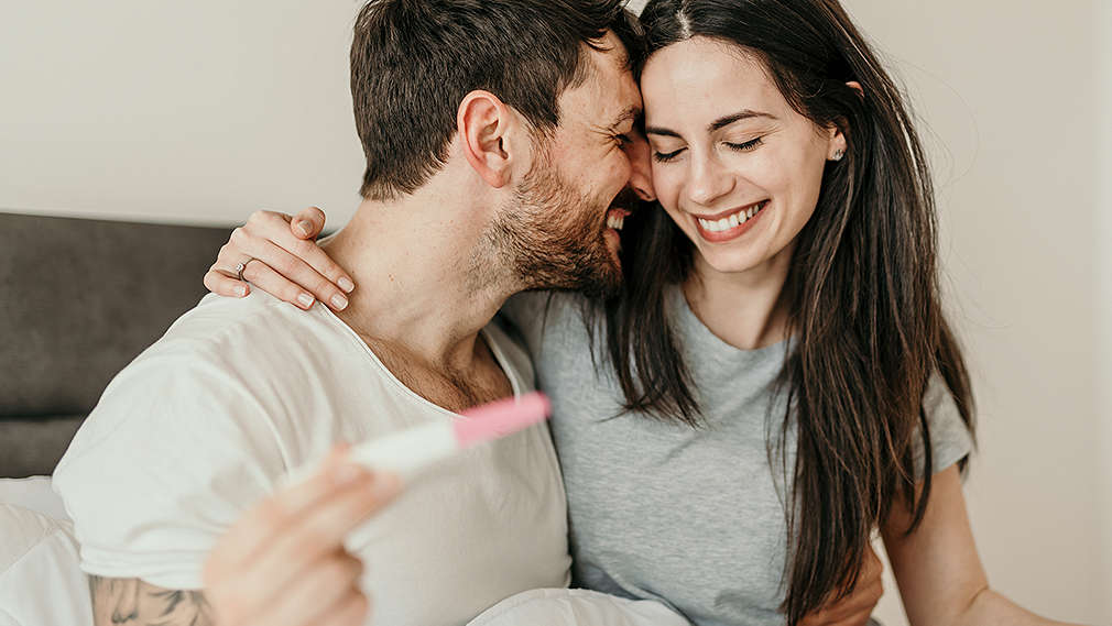 Paar freut sich über positiven Schwangerschaftstest